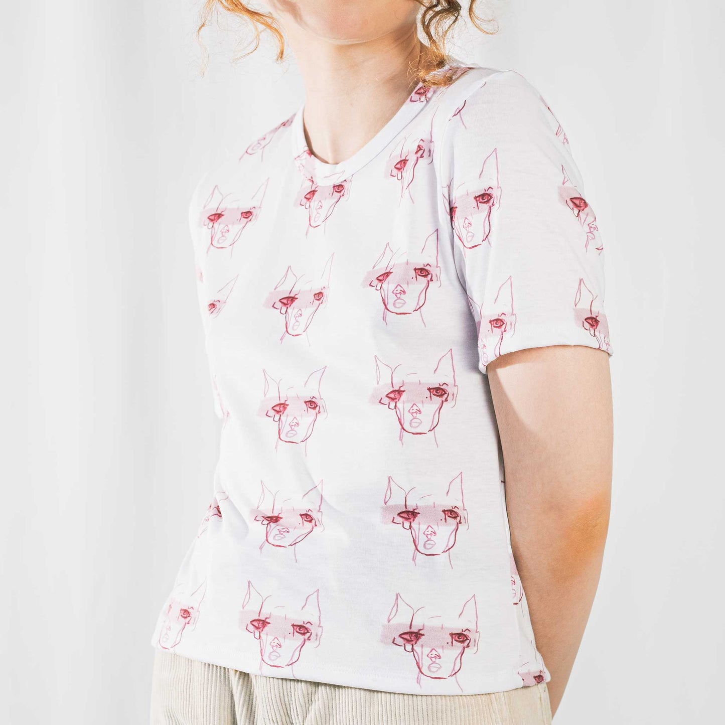 Fashion model wearing illustrated print of pink pig on a white jersey short sleeved T-Shirt.
