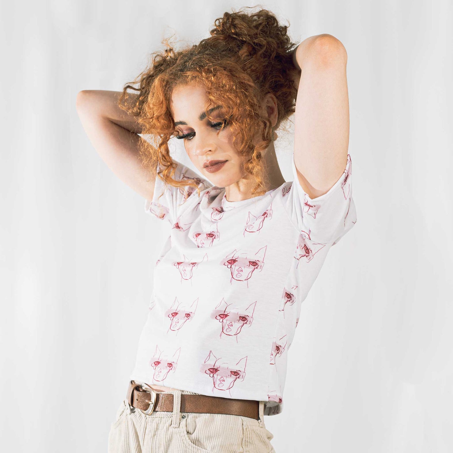 Fashion model wearing illustrated print of pink pig on a white jersey short sleeved T-Shirt.