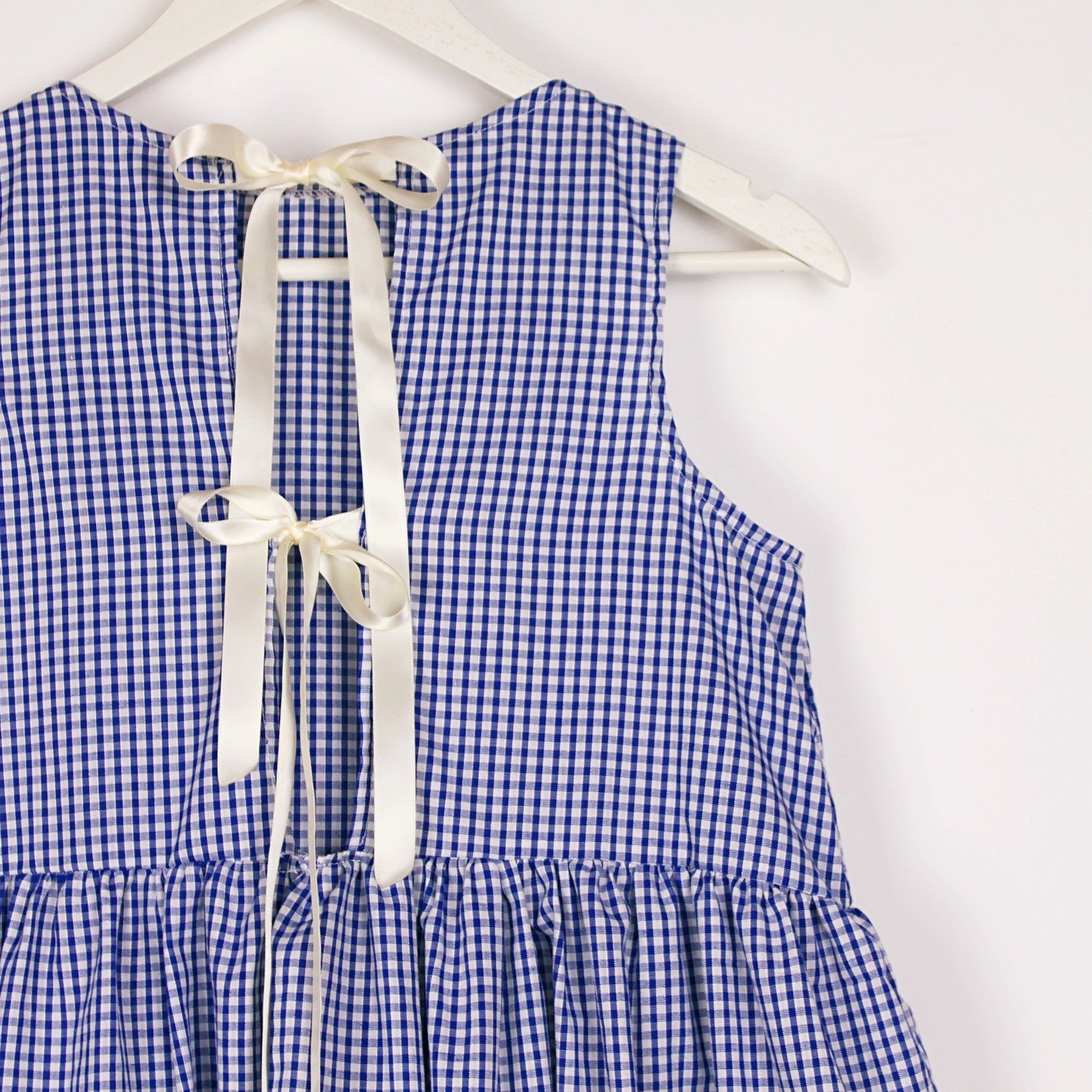 Blue and white checkered dress with a bow on a white background