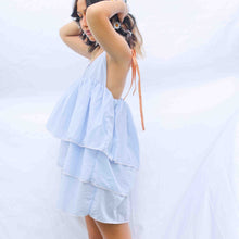 Load image into Gallery viewer, Fashion model wearing pale blue 3 tiered dress with orange elasticated straps at shoulder. 
