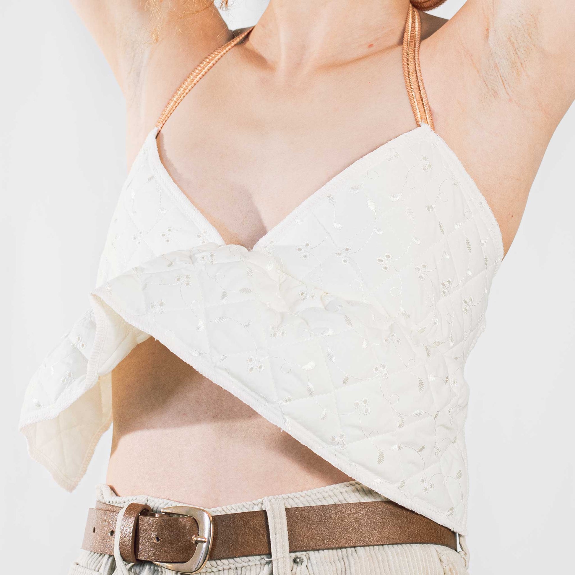 Cream quilted backless bralette with orange elasticated straps at neck and back. 
