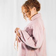 Load image into Gallery viewer, Fashion model wearing pink cuddle fleece oversized jumper with high neck and three quarter zip. Orange elasticated bows through cuffs.
