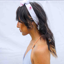 Load image into Gallery viewer, Fashion model wearing illustrated print of pink pig on a white jersey headband.
