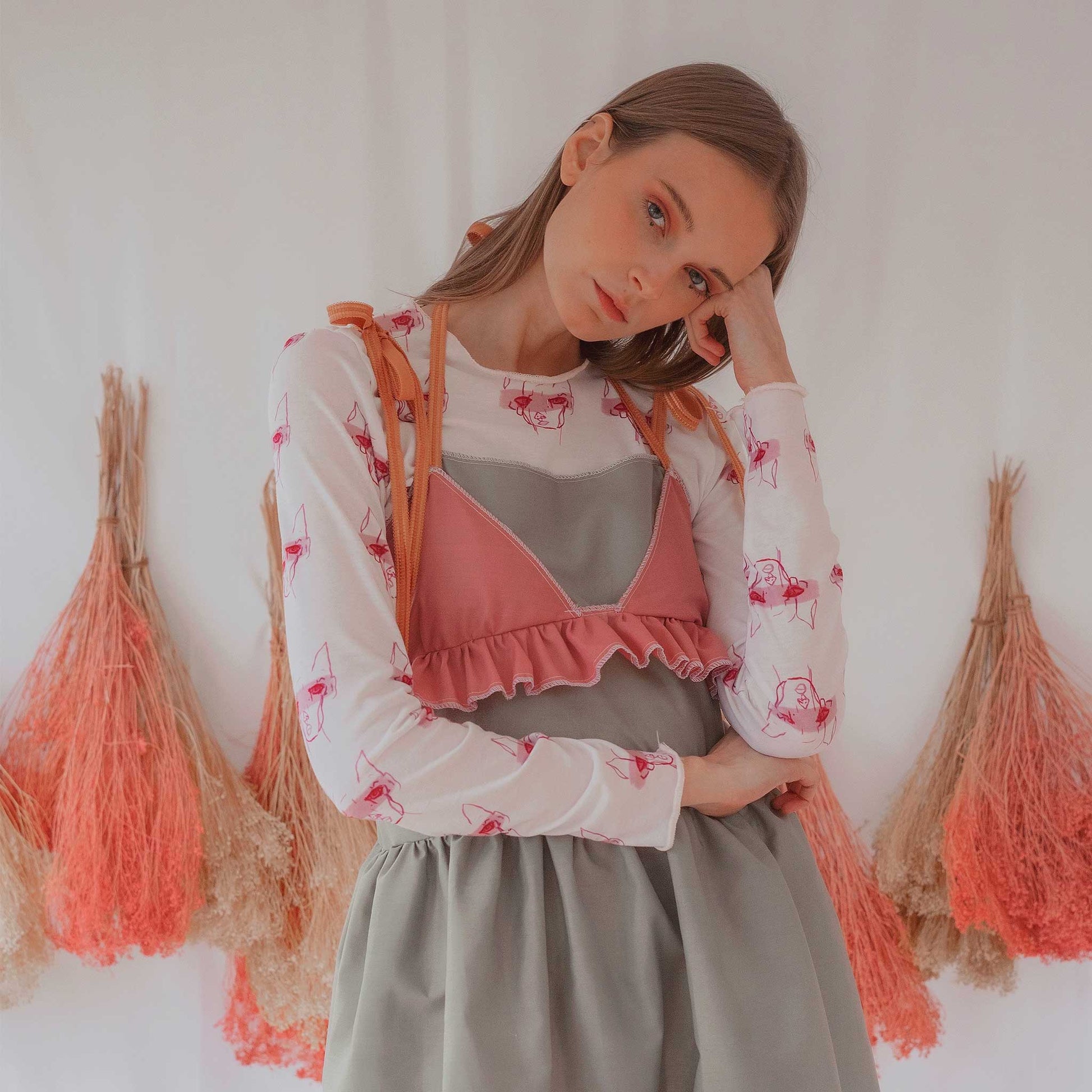 Fashion model wearing illustrated print of pink pig on a white jersey long sleeved T-Shirt.